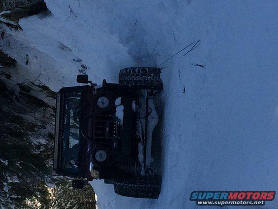 Overturned Jeep in snow, side view