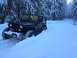 1995 Jeep YJ - A black Jeep Wrangler navigates a snow-covered trail surrounded by snow-laden trees.