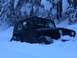 1995 Jeep YJ - A black 1995 Jeep YJ is partially buried in snow during a winter run, with a person visible in the driver's seat.