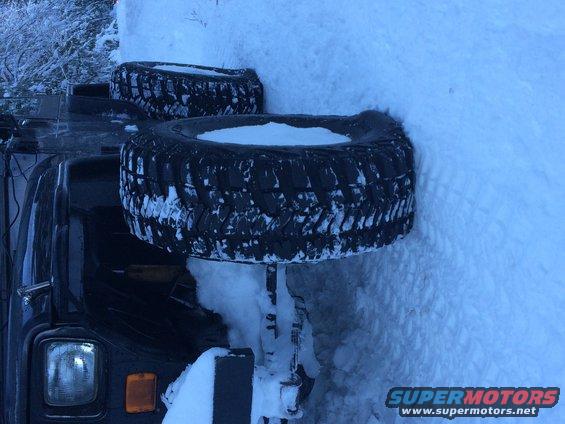 Jeep Wrangler stuck in snow with two spare tires mounted on the side
