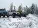 1995 Jeep YJ - Multiple off-road vehicles are parked in a snowy forest during winter.