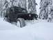 1995 Jeep YJ - A black Jeep Wrangler is partially buried in deep snow, with only its front visible.