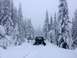 1995 Jeep YJ - 1995 Jeep YJ deep in snow on a wooded trail, with a tow strap attached.