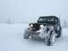 1995 Jeep YJ - A Jeep Wrangler navigates through a snowy landscape with its headlights illuminated.