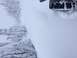 1995 Jeep YJ - A vehicle tire is partially visible, stuck in a snowdrift next to icy trees.