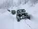 1995 Jeep YJ - Multiple Jeeps navigate a snow-covered trail, with one vehicle being towed.