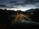 1995 Jeep YJ - Driving on a two-lane road as twilight descends, with a distant house and approaching clouds.