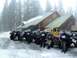 1995 Jeep YJ - A group of people stand with their modified Jeeps in a snowy environment outside a wooden lodge.
