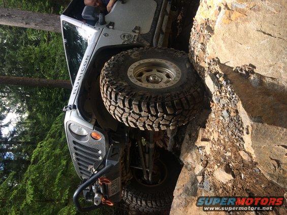 White Jeep Wrangler Rubicon climbing rocks, 2003 model