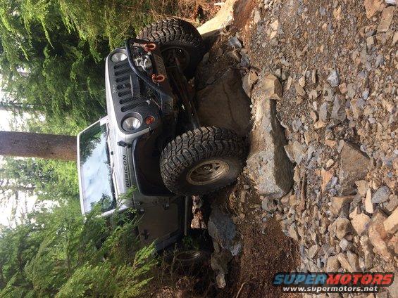 Jeep Wrangler Rubicon going over rocks on a trail. The word "Rubicon" is visible on the side