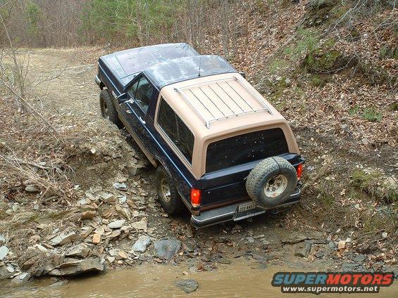 1987 Ford Bronco on a muddy, rocky trail