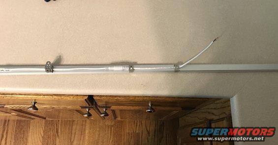 Fluorescent light fixture with exposed wire and Supermotors.net logo