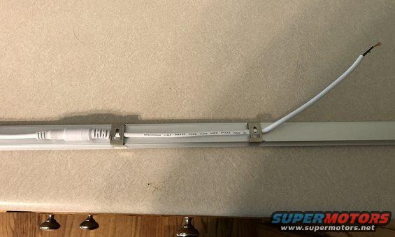 LED light strip mounted with clips, showing wiring and connector