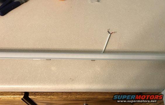 exposed wires coming out of a ceiling fixture above a countertop