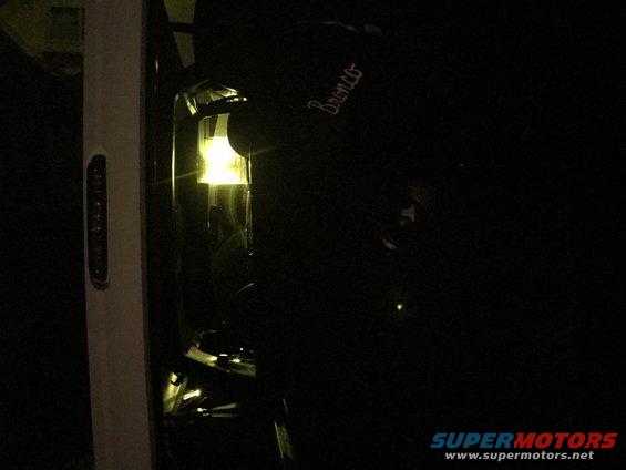 Black Ford Bronco with illuminated headlight and 'Bronco' script on the side