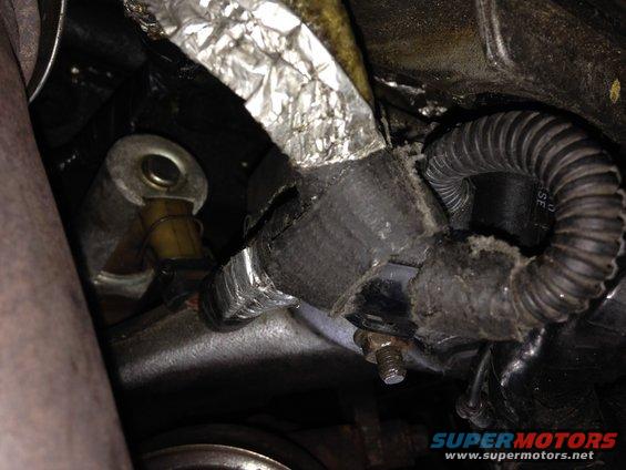 Engine hose with frayed insulation and coiled wiring
