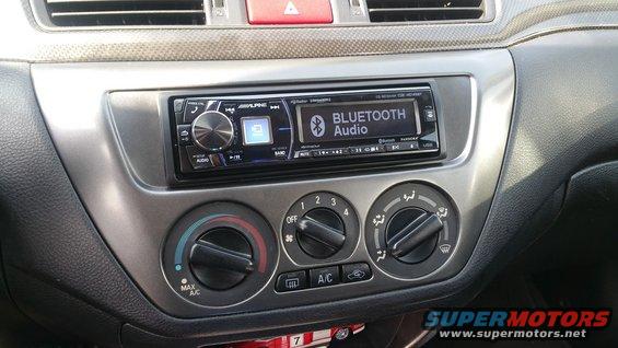 Car interior dashboard with aftermarket Alpine stereo and climate controls