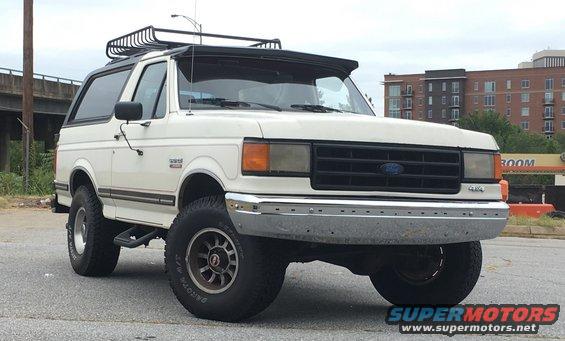 White 1988 Ford Bronco with roof rack, 3/4 front view