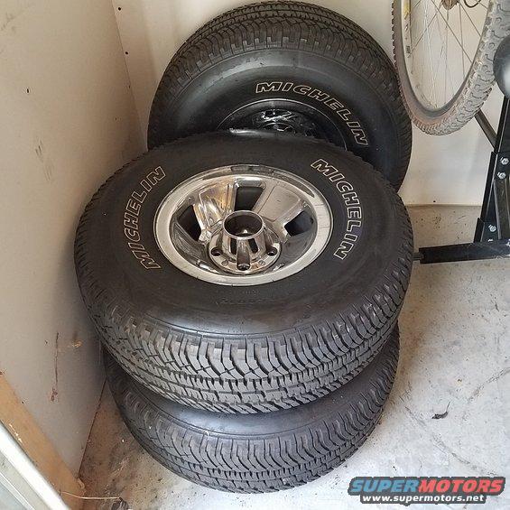 Stack of three Michelin tires with chrome rims, one tire visible on top