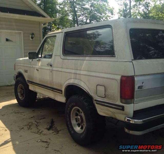 1988 Ford Bronco parked in a driveway next to a garage