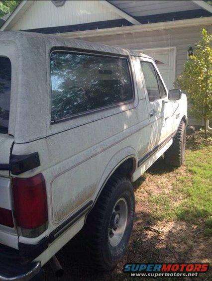 White Ford Bronco parked next to a house