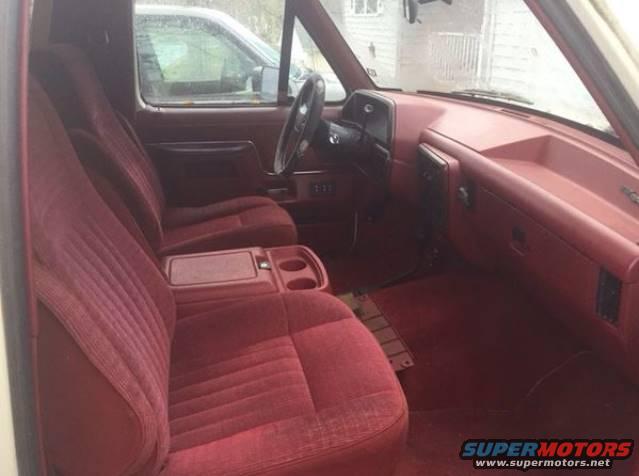 Red velour seats and dashboard of an older SUV, viewed from the passenger side
