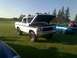 1978 Ford Bronco - A white 1978 Ford Bronco is displayed with its hood up, alongside other vehicles on a sunny day.