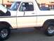 1978 Ford Bronco - A white 1978 Ford Bronco is shown from the side with its hood open, revealing the engine compartment.