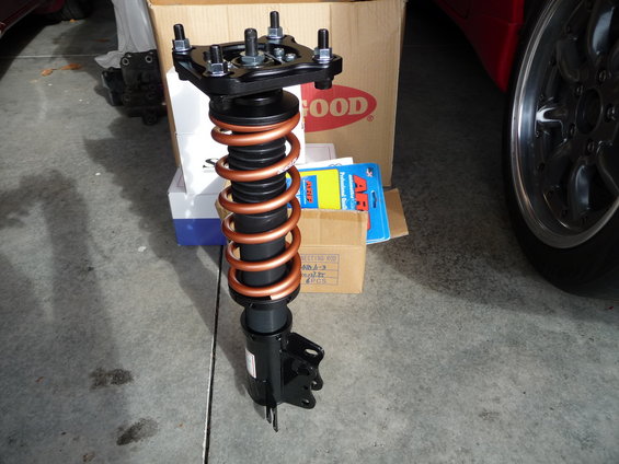Suspension strut with copper coilover spring and "GOOD" logo box