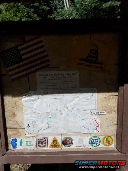 Trail information display with maps, American flag, and Gadsden flag