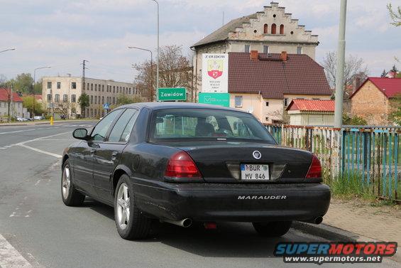 Black Mercury Marauder parked on street with buildings and a sign in background