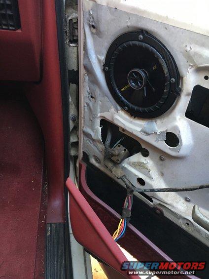 Interior of a car door with the panel removed, showing a Kicker speaker and wiring