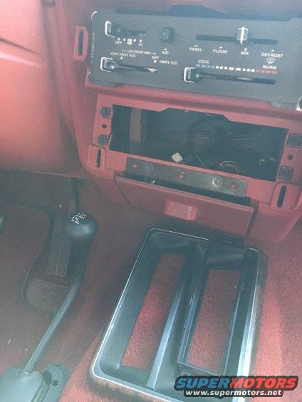 1988 Ford Bronco interior showing dashboard climate controls, gear shifter, and center console area