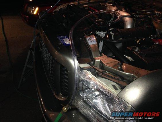 2003 Ford Excursion engine bay with clear tubing and a green hose