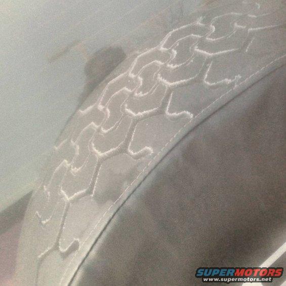 Spare tire cover with hexagonal tread pattern. Supermotors.net logo visible