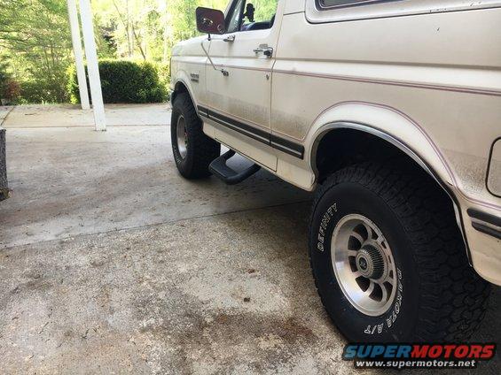 White 1988 Ford Bronco side view with step bars and aftermarket wheels