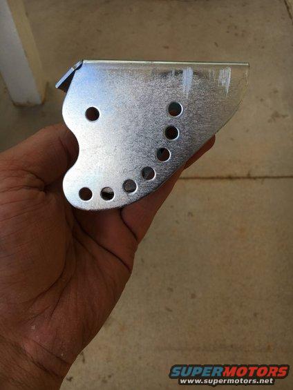 Hand holding a bent metal bracket with multiple holes