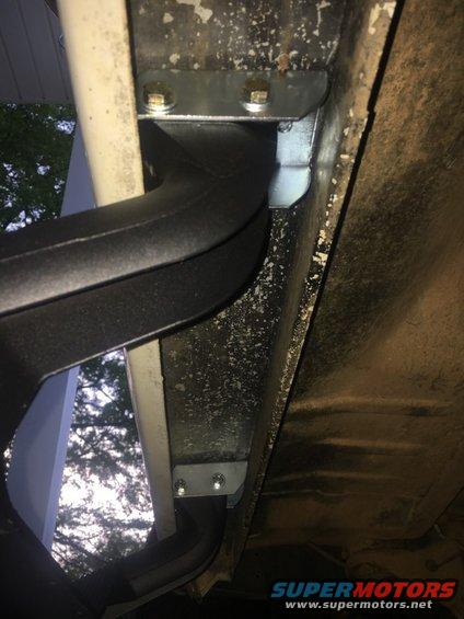Running board bracket bolted to vehicle frame, showing underbody detail
