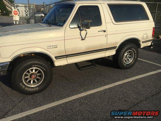 White Ford Bronco with red pinstripes, parked on asphalt