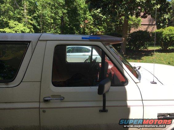 White 1988 Ford Bronco side view with red interior and sun visor