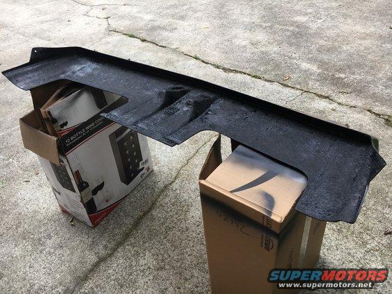 Black plastic car part on boxes