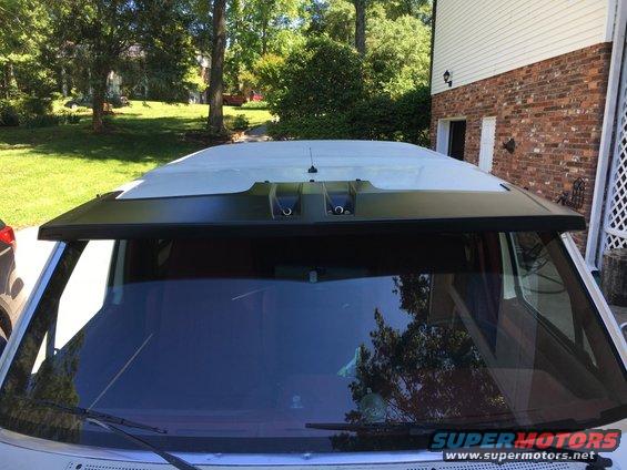 White SUV windshield and roofline with black visor and antenna