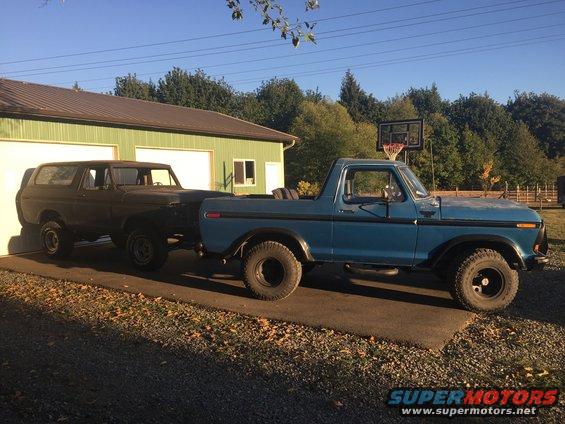 Blue 1978 Ford Bronco pickup truck parked next to a dark SUV
