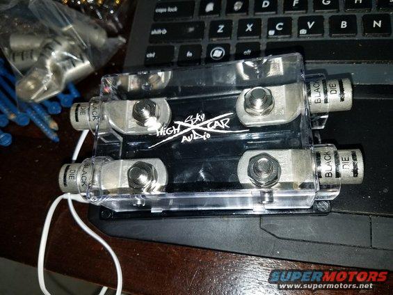 Black car audio power distribution block with four silver terminals and "High Sky Car Audio" logo