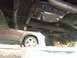 1986 Ford Bronco - The underside of a vehicle shows the transmission pan and filter, with another car parked nearby.