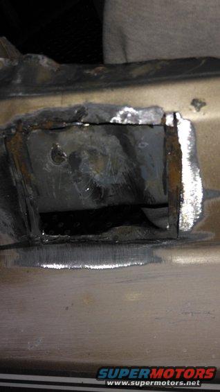 close-up of a metal frame section with fresh welds and a cut-out opening