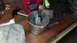 1996 Ford Bronco - A metal component is submerged in a bucket of liquid, with various tools scattered around the workbench.