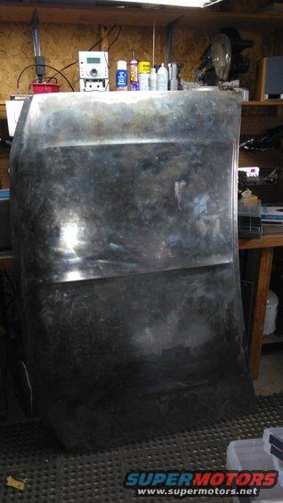 Bare metal hood with visible seams and reflections