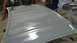 1996 Ford Bronco - A car hood is being sanded and prepped for paint in a workshop setting.