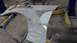 1996 Ford Bronco - A car fender is being repaired with body filler and sanding tools in a workshop.